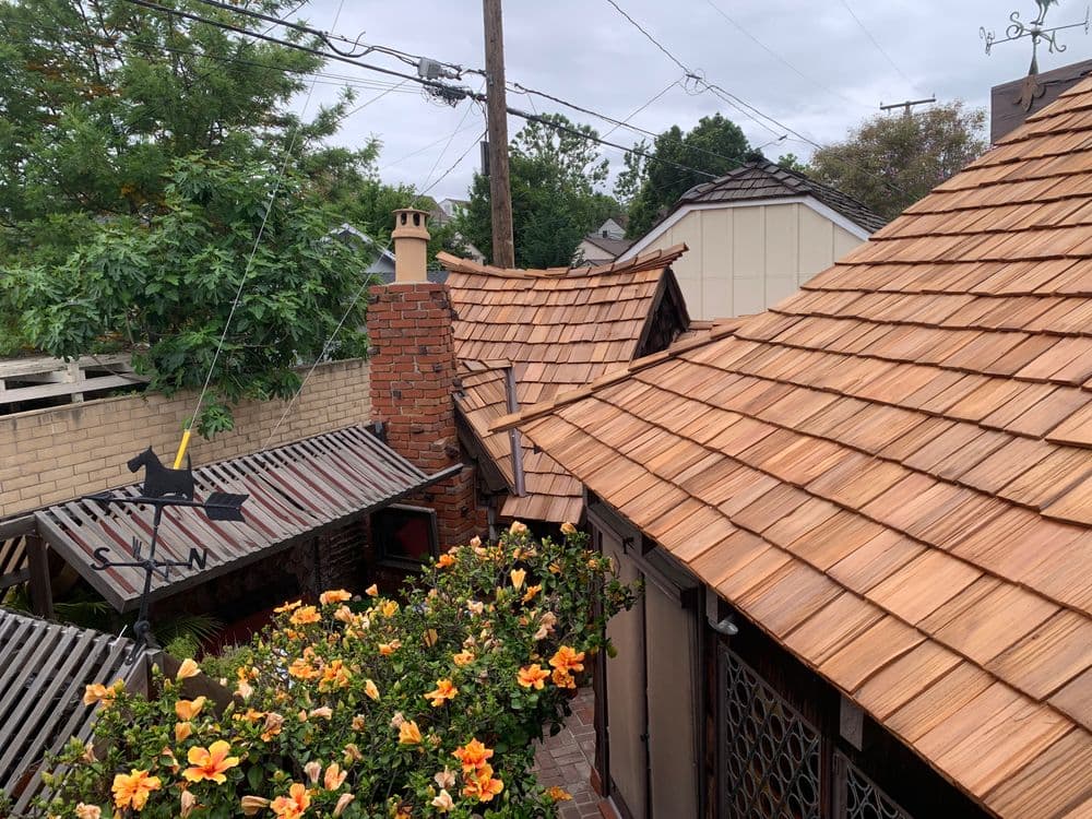 Scenic view of wooden rooftops and vibrant flowers under a cloudy sky.
